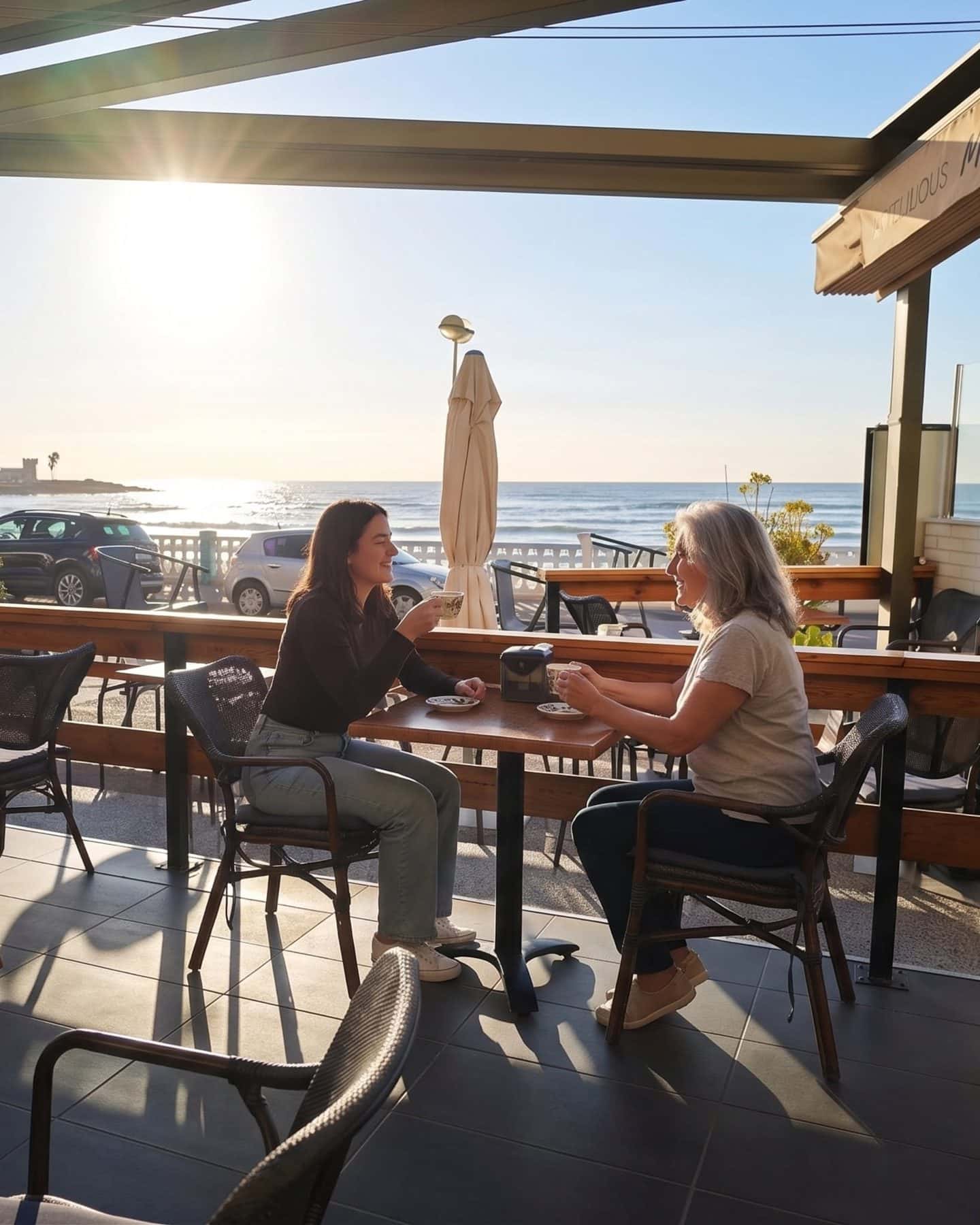 Dos amigas charlando en la terraza de Mango Beach House con el mar de fondo, Playa de los Locos, Torrevieja